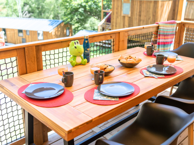 Frühstück auf der Terrasse des Cosyflower Premium im Flower Camping La Plage, Frankreich, gedeckter Tisch.
