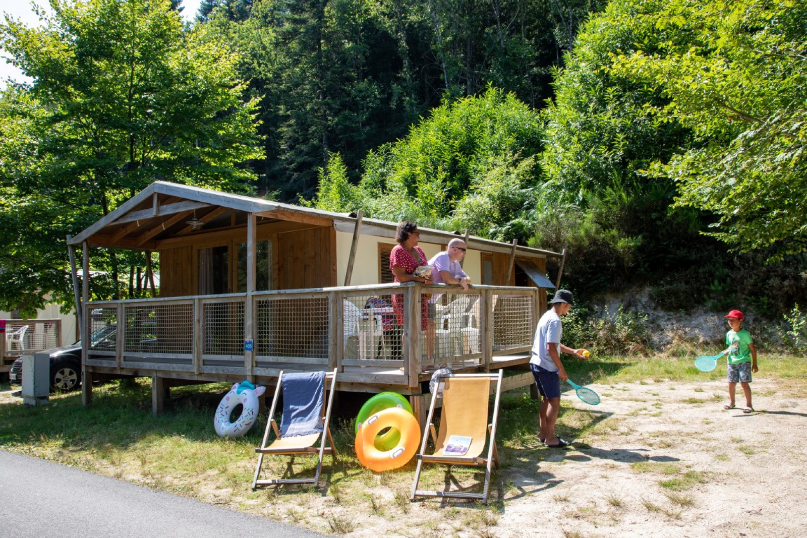 Mensen genieten van de zomer voor een Sweetflower Premium safaritent bij Flower Camping La Plage in Frankrijk.