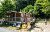 Folk nyder sommeren foran en Sweetflower Premium safari-telt ved Flower Camping La Plage i Frankrig.