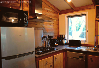 Cucina moderna nella VIP Premium Lodge al Flower Camping La Plage, Francia, con rivestimenti in legno.