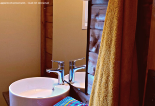 Baño moderno en VIP Premium Lodge en Flower Camping La Plage, Francia, con lavabo y toalla amarilla visible.