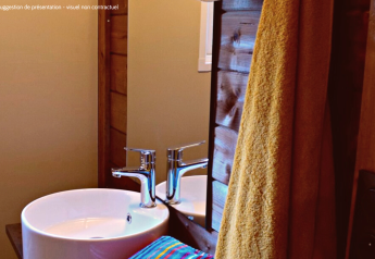 Bagno moderno nel VIP Premium Lodge a Flower Camping La Plage, Francia, con lavabo e asciugamano giallo.