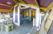 Safari tent Freeflower Standard bij Flower Camping Cap Finistère in Frankrijk met houten meubels en terras.