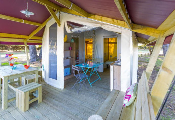 Tenda safari Freeflower Standard al Flower Camping Cap Finistère in Francia, con mobili in legno e terrazza.