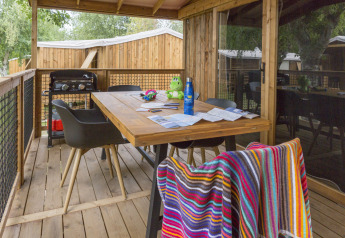 Houten terras bij Cosyflower Premium in Flower Camping Cap Finistère met tafel, stoelen en barbecue.