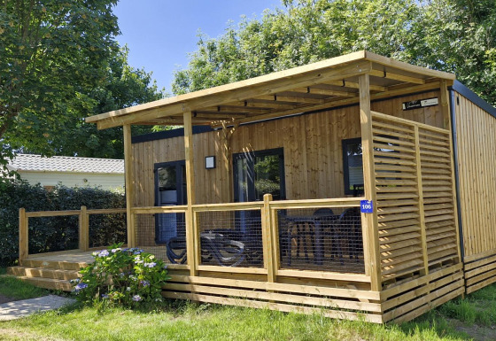 Chalet Homeflower Premium in legno con veranda coperta, zona relax esterna e circondato dal verde.