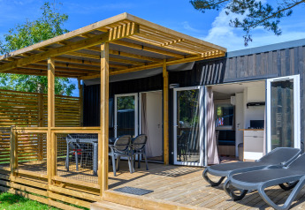 Buitenterras met ligstoelen en tuintafel bij Homeflower premium lodge op Flower Camping Cap Finistère, Frankrijk.