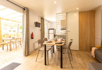 Zona pranzo e soggiorno luminosa di Stacaravan Premium al Flower Camping Le Vieux Moulin, Francia.