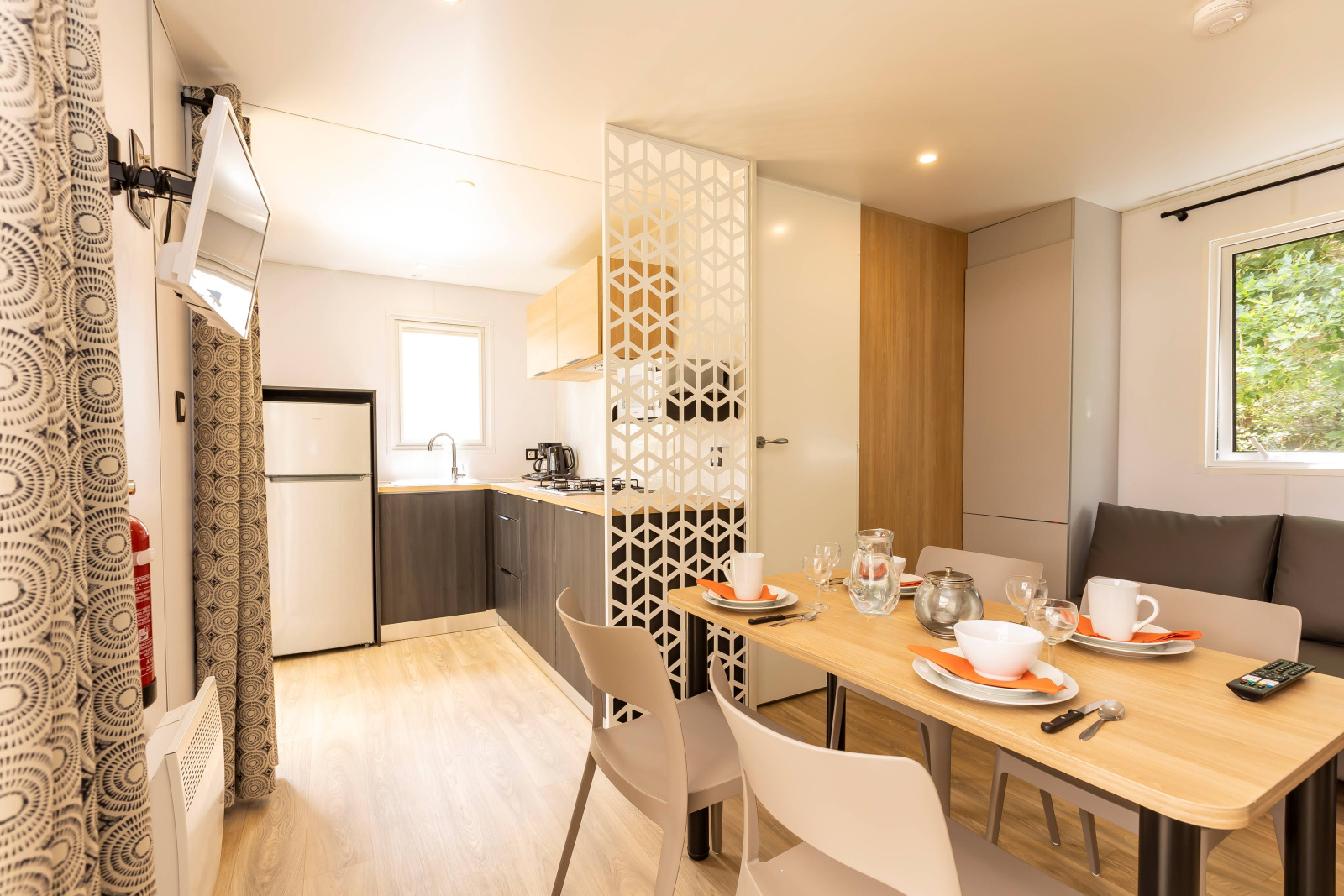 Interieur van de Stacaravan Premium bij Flower Camping Le Vieux Moulin met eettafel en keuken.