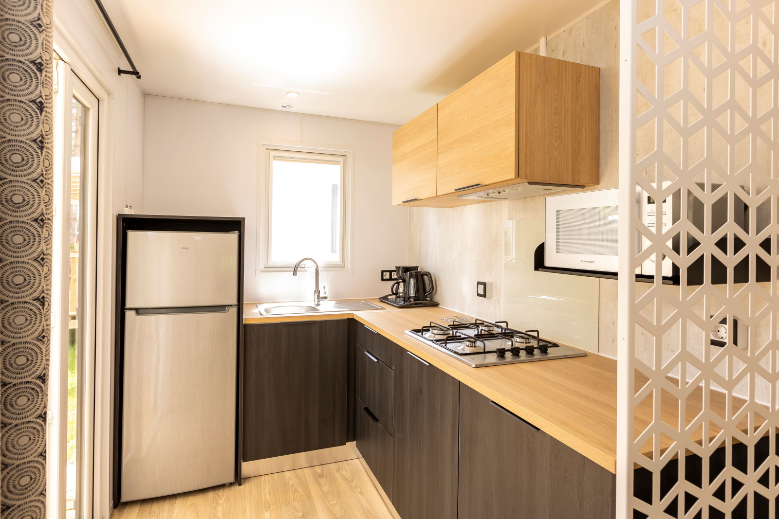 Moderne keuken in Stacaravan Premium bij Flower Camping Le Vieux Moulin in Frankrijk met lichte houttinten.