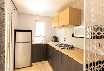 Cucina moderna in Stacaravan Premium al Flower Camping Le Vieux Moulin in Francia, con rifiniture in legno chiaro.