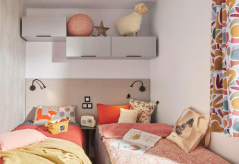 Chambre double chaleureuse au Stacaravan Premium du Flower Camping Le Vieux Moulin en France, décorée avec soin.