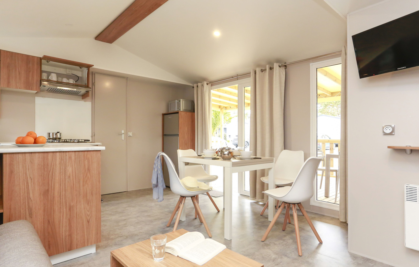 Lichte, moderne keuken en eethoek in een Stacaravan Premium bij Flower Camping Le Vieux Moulin in Frankrijk.