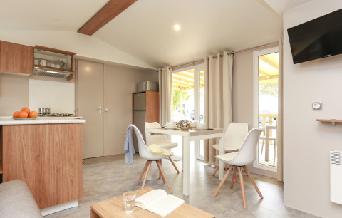 Bright and modern kitchen and dining area in a Stacaravan Premium at Flower Camping Le Vieux Moulin, France.