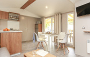 Bright and modern kitchen and dining area in a Stacaravan Premium at Flower Camping Le Vieux Moulin, France.
