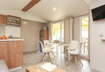Cucina e zona pranzo luminose e moderne in una Stacaravan Premium al Flower Camping Le Vieux Moulin, Francia.