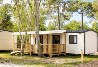 Vue extérieure du chalet Stacaravan Premium au Flower Camping Le Vieux Moulin en France, entouré d’arbres.