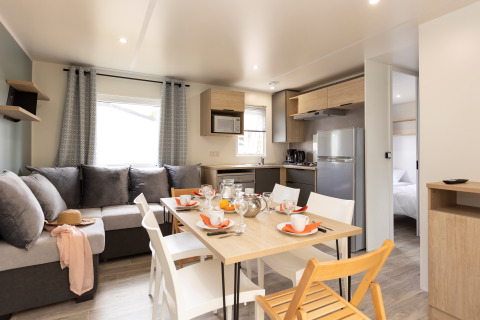 Salón y cocina modernos y luminosos en Stacaravan Premium en Flower Camping Le Vieux Moulin, Francia.