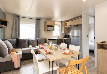 Bright living room and kitchen in Stacaravan Premium at Flower Camping Le Vieux Moulin, modern and cozy.