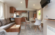 Sala y cocina modernas en Stacaravan Premium del Flower Camping Le Vieux Moulin en Francia.