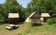 Safari-Zelte Standaard bivak op palen bei Flower Camping Mas de Champel in Frankreich, umgeben von Bäumen.