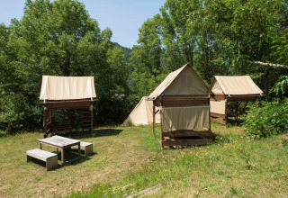 Tentes safari Standaard bivak op palen au Flower Camping Mas de Champel en France, entourées de verdure.