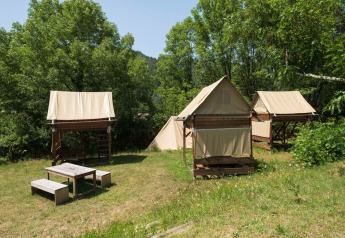 Standaard bivak op palen safaritenten op Flower Camping Mas de Champel in Frankrijk, te midden van natuur.