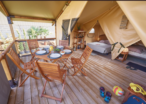 Safari teltet Bali Safari Tent ved Flower Camping Mas de Champel i Frankrig med terrassemøbler og soveområde.