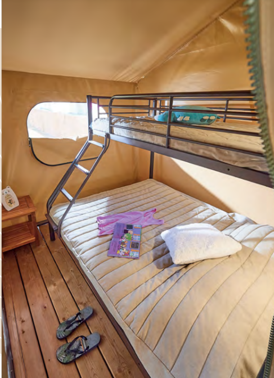Interieur van de Bali Safari Tent bij Flower Camping Mas de Champel met stapelbedden en houten vloer.