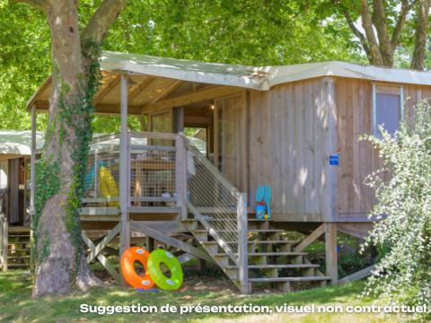 CosyFlower Premium lodge bij Flower Camping Mas de Champel in Frankrijk, met houten terras en kinderspeelgoed.