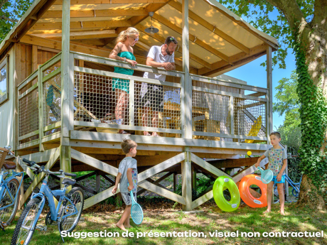 Familie verbringt einen Sommertag an einer CosyFlower Premium Lodge mit Kindern, Fahrrädern und Spielzeug.