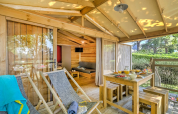 Houten terras met eettafel en ligstoelen bij CosyFlower Premium Lodge, Flower Camping Mas de Champel, Frankrijk.