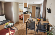 Moderne Homeflower Premium-lodge met open keuken, eettafel, zitgedeelte en zichtbare slaapkamer.