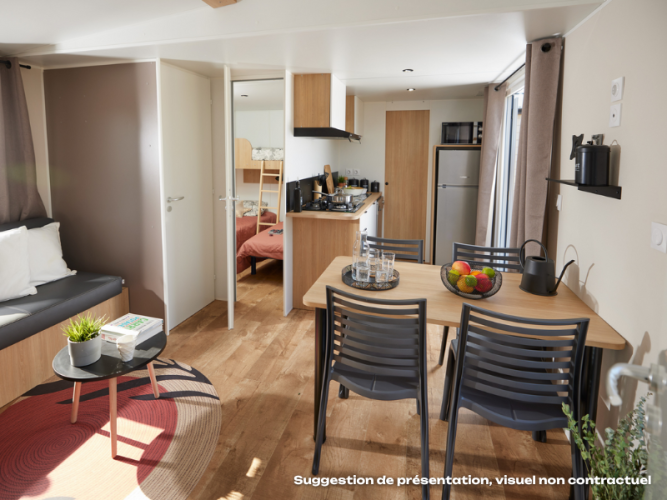 Bright Homeflower Premium lodge featuring kitchen, dining area, cozy sofa, and visible bedroom.