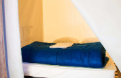 Vista interior de una acogedora cama en Funflower Standaard, Flower Camping Les Paludiers, Francia.
