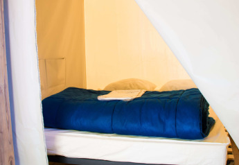 Vista interna di un letto accogliente nella Funflower Standaard al Flower Camping Les Paludiers, Francia.