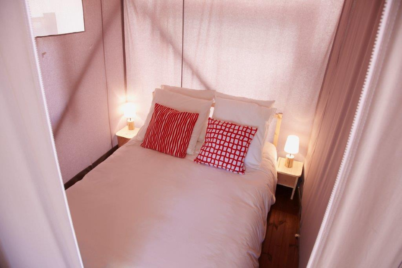 Slaapkamer in een safaritent, Cabane Lodge op palen Standard bij Flower Camping Les Paludiers, Frankrijk.