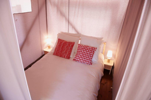 Bedroom arrangement in a safari tent, Cabane Lodge op palen Standard at Flower Camping Les Paludiers, France.