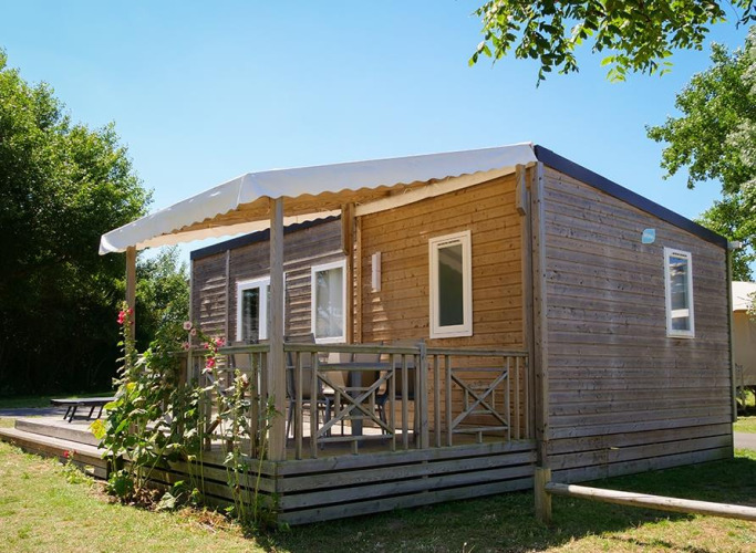 Lodge Stacaravan Premium en Flower Camping Les Paludiers en Francia, rodeado de árboles y naturaleza.