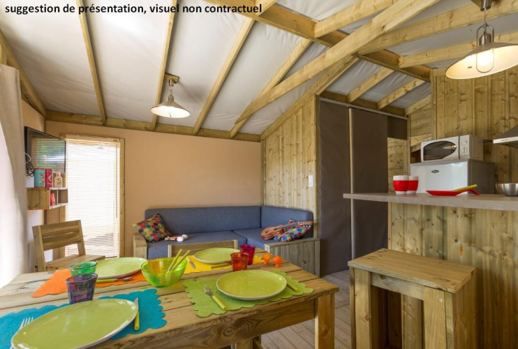 Vista interior del lodge Sweetflower op palen Premium en Flower Camping Les Paludiers en Francia, con comedor y cocina.