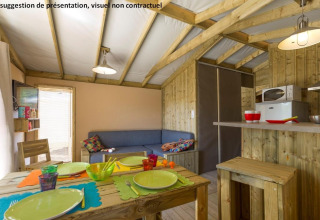 Interieur van de Sweetflower op palen Premium lodge bij Flower Camping Les Paludiers in Frankrijk met keuken en eetruimte.