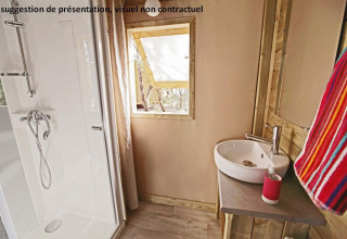 Badkamer in Sweetflower op palen Premium lodge bij Flower Camping Les Paludiers met douche en wastafel.