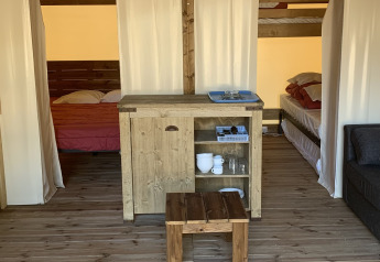 Binnenkant van een Freeflower Standaard safaritent op Flower Camping Le Bel Air, met houten meubels en bedden.