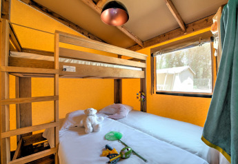 Chambre sous tente safari Ecolodge Cotton Comfort au Flower Camping Le Bel Air, avec lit superposé et fenêtre.