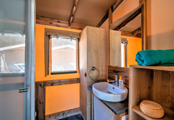 Badeværelse i Ecolodge Cotton Comfort-safaritelte på Flower Camping Le Bel Air med vask og spejl.