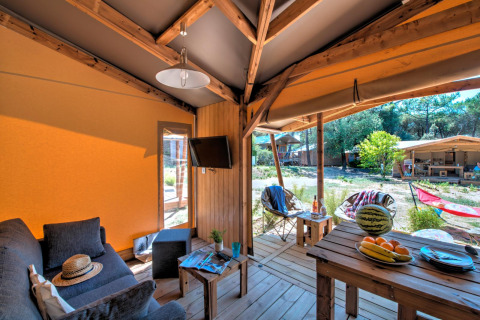 Interieur van de Blokhut Cotton Comfort safaritent bij Flower Camping Le Bel Air in Frankrijk met terras.