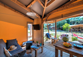 Interieur van de Blokhut Cotton Comfort safaritent bij Flower Camping Le Bel Air in Frankrijk met terras.