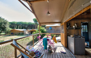 Porch view of the Hut Lodge Comfort at Flower Camping Le Bel Air in France, showing outdoor seating and kitchen.