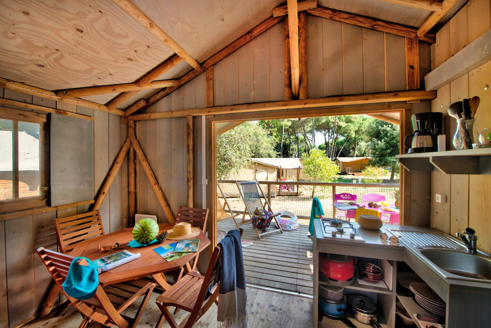 Binnenaanzicht van Hut Lodge hout Comfort bij Flower Camping Le Bel Air met terras en bosuitzicht.
