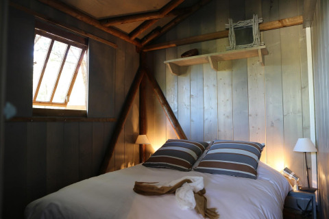 Cozy bedroom in a wooden cabin at Hut Lodge hout Comfort, Flower Camping Le Bel Air, France.